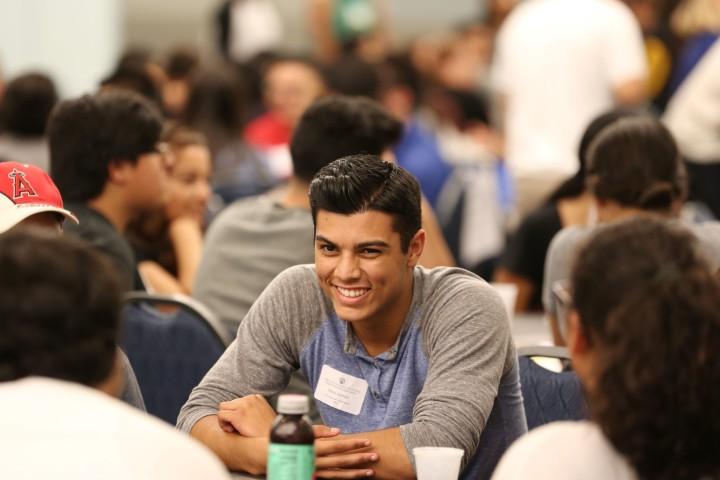 Student with name tag smiling at other students